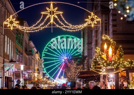 Schwerin, Deutschland. Dezember 2024. Am Weihnachtsmarkt hinter der Mecklenburgstraße dreht sich ein Riesenrad. In Mecklenburg-Vorpommern enden die meisten großen Weihnachtsmärkte wenige Tage vor Heiligabend - nur in Schwerin und Stralsund können Sie nach den Feiertagen noch den Glühweinstand und den Mutzenstand besuchen. Der Schweriner Markt endet am 30. Dezember, der Stralsunder Markt endet erst im Dezember 31. Quelle: Jens Büttner/dpa/Alamy Live News Stockfoto