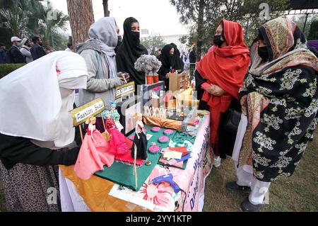 Die Besucher interessieren sich für die Stände der Science and IT Exhibition, die am Mittwoch, den 18. Dezember 2024, im Government College in Peshawar stattfand. Stockfoto