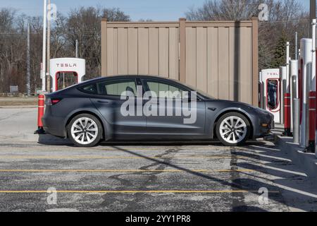 Lafayette - 17. Dezember 2024: Tesla EV Elektrofahrzeug an einem Kompressor. Zu den Produkten von Tesla gehören Elektroautos, Batteriespeicher und Solaranlagen Stockfoto