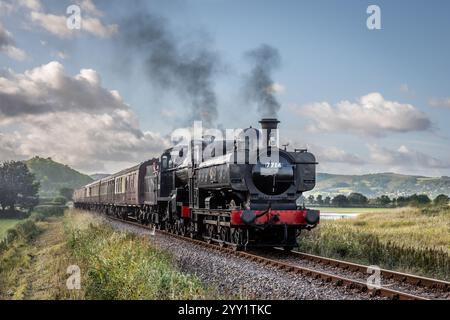 BR '57xx' 0-6-0PT Nr. 7714 und BR '7F' 2-8-0 Nr. 53808 nähern sich der Blue Anchor Station an der West Somerset Railway, Somerset, England, Großbritannien Stockfoto