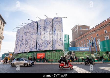 Blick auf Autos, die neben „Konstellationen von Rom“ vorbeifahren, dem Titel der monumentalen Intervention, die Pietro Ruffo auf den zehn Silos unterzeichnet hat, die die Baustelle der Metro C auf der Piazza Venezia begrenzen. Das erste Werk eines Zyklus wurde vorgestellt, der sich in den kommenden Monaten auf dieser neuen Oberfläche abwechseln wird, die der zeitgenössischen Kunst verliehen wird. Mit „Murales“, dem Titel des Projekts, das von Webuild, einem Unternehmen, das am Bau der C-Linie der U-Bahn in Rom arbeitet, gefördert wurde, verwandelt sich die Baustelle in eine Gelegenheit zur Stadterneuerung. Stockfoto