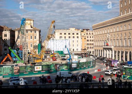 Rom, Italien. Dezember 2024. Kräne und LKWs rund um die „Konstellationen von Rom“, den Titel der monumentalen Intervention, die Pietro Ruffo auf den zehn Silos unterzeichnet hat, die die Baustelle der Metro C auf der Piazza Venezia begrenzen. Das erste Werk eines Zyklus wurde vorgestellt, der sich in den kommenden Monaten auf dieser neuen Oberfläche abwechseln wird, die der zeitgenössischen Kunst verliehen wird. Mit „Murales“, dem Titel des Projekts, das von Webuild, einem Unternehmen, das am Bau der C-Linie der U-Bahn in Rom arbeitet, gefördert wurde, verwandelt sich die Baustelle in eine Gelegenheit zur Stadterneuerung. (Bild: © Stefano Co Stockfoto