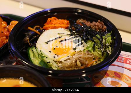 Genießen Sie einen köstlichen Teller Bibimbap, der ein perfekt gekochtes Ei und frisches Gemüse enthält Stockfoto