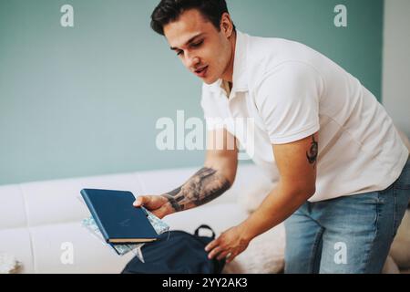 Junge Studentin packt Bücher in den Rucksack, bevor sie zu Hause geht Stockfoto