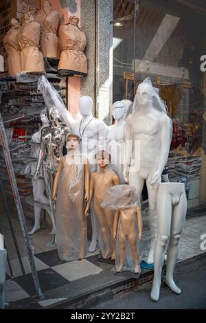 Eine Ausstellung von in Plastik gewickelten Schaufensterpuppen vor einem Geschäft in Alexandria, Ägypten, zeigt verschiedene Formen, von Erwachsenen bis zu Kindern für Kleidung Stockfoto