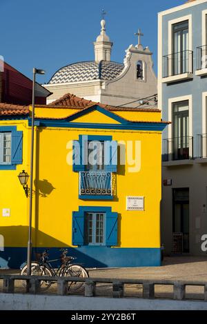 AVEIRO, PORTUGAL - 30. AUGUST 2019: Cais dos Botiroes und die gelbe Casa do Mercado in einem der Kanäle von Aveiro mit den typischen Häusern und moli Stockfoto