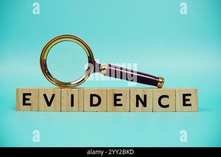 Beweise mit Holzblöcken Buchstaben und Vergrößerungsglas auf blauem Hintergrund Stockfoto