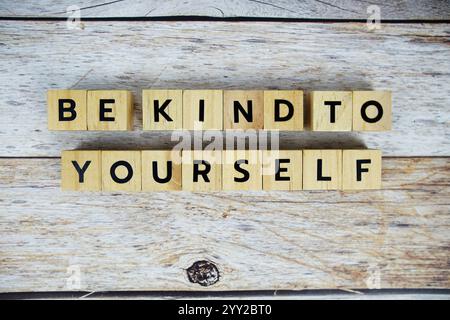 Mit Holzblöcken mit Buchstaben auf hölzernem Hintergrund können Sie sich ganz allein fühlen Stockfoto