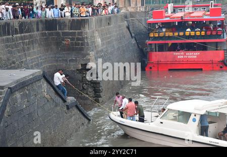 Indien. Dezember 2024. MUMBAI, INDIEN - 18. DEZEMBER: Rettete Passagiere am Gateway of India, nachdem das Schiff in Mumbai, Indien, am 18. Dezember 2024 in der Nähe von Elephanta gekentert hatte. Dreizehn Menschen wurden getötet, nachdem ein Schnellboot der indischen Marine die Kontrolle verloren hatte und auf ein Passagierboot stürzte, das Passagiere von Elephanta Island zum Gateway of India brachte. Zu den Toten gehören 12 Zivilisten, darunter zwei auf dem Marineschiff und ein Beamter der Indischen Marine. (Foto: Bhushan Koyande/Hindustan Times/SIPA USA) Credit: SIPA USA/Alamy Live News Stockfoto