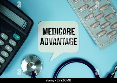 Medicare Advantage Text auf Sprechblase mit Rechner und Stethoskop Draufsicht auf blauem Hintergrund Stockfoto