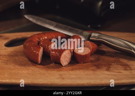 Wurst auf Holzbrett und Messer schneiden Stockfoto