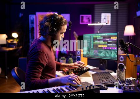 Tontechniker bearbeiten Soundtracks und passen die Lautstärke über die daw Software-Schnittstelle an, die in der Musikindustrie in der Post-Production arbeitet. Songwriter Producer erstellt neue Songs mit Audioaufnahmen. Stockfoto