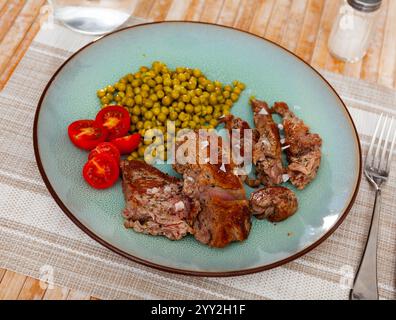 Über offenem Feuer gekochtes Rindfleisch mit appetitlicher Kruste und dunklen Streifen mit Kirschtomaten und Bohnen Stockfoto