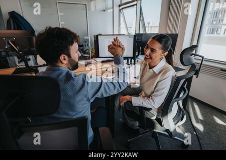 Geschäftsleute feiern Erfolg mit einem kreativen Arbeitsbereich Stockfoto