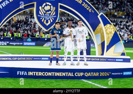 Doha, Katar. Dezember 2024. Bronzeballpreis Elias Montiel defensives Mittelfeld von Pachuca und Mexiko, Golden Ball Award, Vinicius Junior linker Flügelspieler von Real Madrid und Brasilien und Silver Ball Award Federico Valverde zentrales Mittelfeld von Real Madrid und Uruguay posiert zum Foto nach dem Finale des FIFA Intercontinental Cup 2024 zwischen dem spanischen Real Madrid und dem mexikanischen Pachuca am 18. Dezember im Lusail Stadium in Doha, Katar, 2024. Foto: Ahmed Alsaidi/DiaEsportivo/Alamy Live News Credit: DiaEsportivo/Alamy Live News Stockfoto