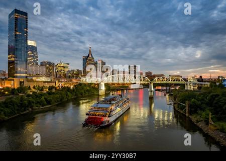 General Jackson Showboat auf dem Cumberland River bei Sonnenuntergang mit der berühmten Skyline von Nashville und der John Seigenthaler Fußgängerbrücke im Blick. Stockfoto