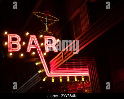Das Vintage-Neonschild der Murray Bar mit pinkem Schriftzug und einem stilvollen Cocktail. Fotografiert bei Nacht in Livingston, Montana Stockfoto