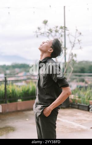Ein südostasiatischer Mann, der in den Himmel blickt und den Moment genießt Stockfoto