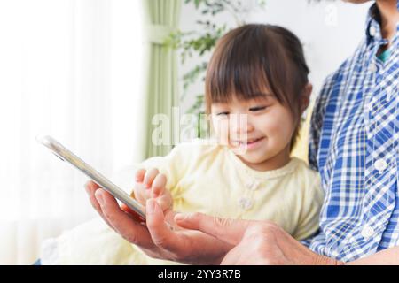 Kind, das ein Telefon mit Oma benutzt Stockfoto