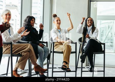 Verschiedene Gruppen glücklicher Menschen, die aktiv an einer Präsentation des Business Panels teilnehmen und Engagement und Begeisterung zeigen. Stockfoto