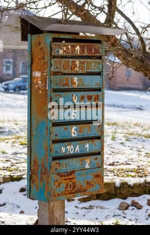 Alte blaue Briefkästen stehen auf der Straße. Ein alter Briefkasten in der Nähe des Hauses Stockfoto