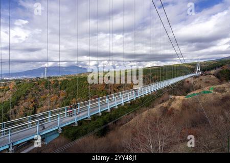 Blick auf die Mishima Skywalk Bridge, die längste Fußbrücke Japans, an einem sonnigen Tag mit sich bewegenden Wolken im Hintergrund Stockfoto