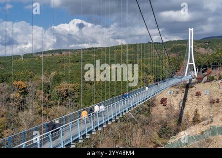 Blick auf die Mishima Skywalk Bridge, die längste Fußbrücke Japans, an einem sonnigen Tag mit sich bewegenden Wolken im Hintergrund Stockfoto