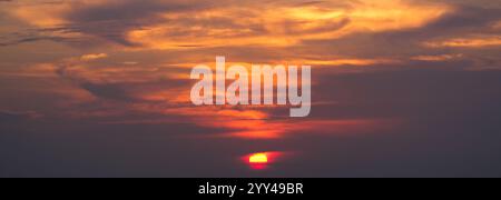 Ein leuchtend roter Sonnenuntergang erfüllt den Himmel mit warmen, feurigen Tönen Stockfoto