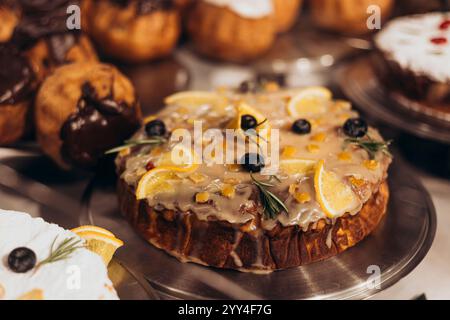 Eine verlockende Auswahl an Gebäck und Kuchen in einem Bäckereifenster, mit verschiedenen Texturen und Geschmacksrichtungen und dekorativen Garnituren Stockfoto