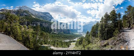 Entdecken Sie den atemberaubenden Oeschinensee eingebettet in die Schweizer Alpen dieses Foto fängt die weitläufigen Bergaussichten, üppigen Wälder und den dynamischen Himmel ein Stockfoto