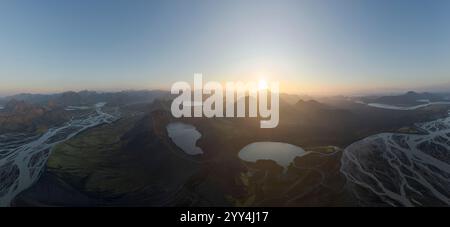 Ein atemberaubender Blick aus der Vogelperspektive auf Islands zerklüftete Landschaft mit gewundenen Flüssen und sonnengeküssten Bergen, diese ruhige Szene fängt die natürliche Schönheit ein Stockfoto