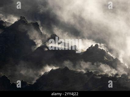 Nebel driftet über dramatische Lavaformationen in einer isländischen Landschaft und schafft eine unheimliche und mystische Atmosphäre, das zerklüftete Gelände und die vulkanischen Felsen e Stockfoto