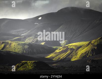 Atemberaubende isländische Landschaft mit lebendigen grünen Bergen unter dramatischem Himmel die ruhige Szene fängt die mystische und raue Schönheit der Natur ein Stockfoto