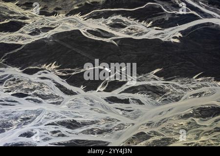 Aus der Vogelperspektive mit komplexen Flussmustern, die sich durch Islands vulkanische Landschaft schlängeln. Der starke Kontrast von Schwarz und weiß unterstreicht die Natur Stockfoto