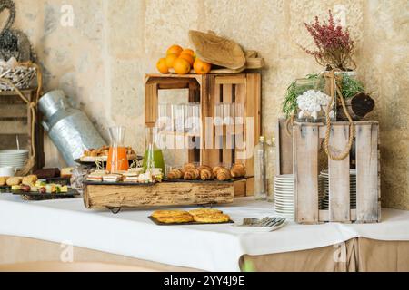 Ein wunderschön gestaltetes rustikales Büfett bietet frisches Obst, Säfte, Gebäck und Sandwiches, perfekt für ein Hotel, Spa oder Weinberg-Ambiente Stockfoto