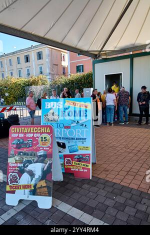 Civitavecchia, Italien - 19. Dezember 2024: Menschen stehen an einem Ticketschalter unter einem Baldachin in Schlange und kaufen Tickets für Busverbindungen nach Rom, Fiumicino ai Stockfoto