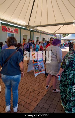 Civitavecchia, Italien - 19. Dezember 2024: Touristen stehen an einem Kiosk für Tickets für die TOUR DURCH ROM an und bieten Touren zu den nahe gelegenen Sehenswürdigkeiten an Stockfoto