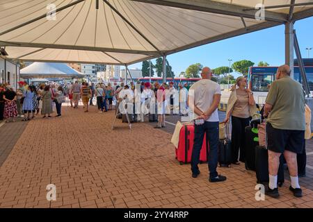 Civitavecchia, Italien - 19. Dezember 2024: Touristen stehen an einem Kiosk für Tickets für DIE TOUR durch ROM an, mit Minibus- und Kleinbus-Touren zu nahe gelegenen Sehenswürdigkeiten. Stockfoto