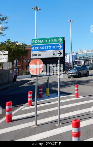 Civitavecchia, Italien – 19. Dezember 2024: Ein Richtungsschild an einer städtischen Kreuzung in Civitavecchia, das auf ROMA (A12, E80), GROSSETO (SS1) zeigt Stockfoto