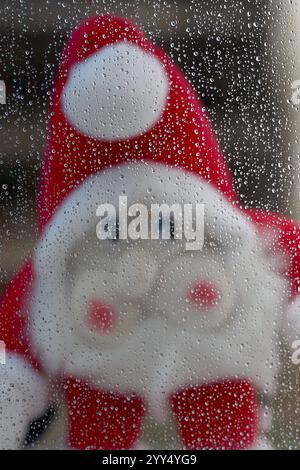 Auch in diesem Jahr sieht es es im Siegerland nicht nach Weißen weißen Weihnachten aus. Ein Trister Vormittag im Siegerland. Es regnet immer wieder stark. Eine Nikolausfigur schaut durch ein Fenster an dem Regentropfen haengen hängen. Herbst im Siegerland am 19.12.2024 in Siegen/Deutschland. *** Es sieht nicht aus wie eine weiße Weihnachten im Siegerland in diesem Jahr, auch nicht Ein trostloser Morgen im Siegerland es regnet immer wieder stark Eine Weihnachtsmannfigur schaut durch ein Fenster mit Regentropfen, die davon hängen Herbst in Siegerland am 19. Dezember 2024 in Siegen Stockfoto