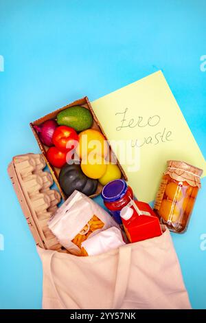 Ein Bild von umweltfreundlichen Produkten und wiederverwendbaren Verpackungen, einschließlich frischem Gemüse, Glasgläsern und Kartonbehältern, in einem Baumwollbeutel Stockfoto