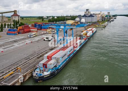 Containerbeladung im Hafen von Mulhouse Ottmarsheim am Canal Grande des Elsass, parallel zum Rhein. Containerschiff im industriellen Flusshafen Stockfoto