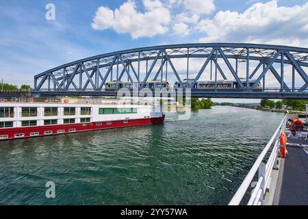 Das Flusskreuzfahrtschiff Sound of Music landet in Straßburg auf dem Rheinaufstieg, am Rhone-Rhein-Kanal im Vauban-Hafen. Straßenbahn auf einer Brücke Stockfoto