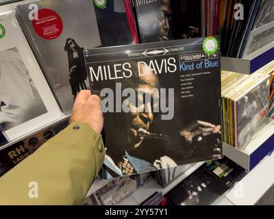Straßburg, Frankreich - 17. Dezember 2024: Miles Davis Art of Blue Schallplatte in einem Musikladen, umgeben von klassischen und modernen Alben, zum Kauf bereit. Stockfoto