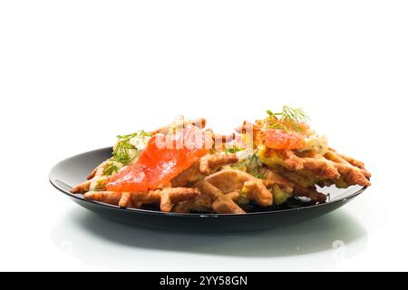 Gemüskartoffelwaffeln mit Aufstrich und leicht gesalzenem rotem Fisch auf einem Teller, isoliert auf weißem Hintergrund. Stockfoto