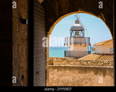 Blick auf den Leuchtturm und das smaragdgrüne Meer im Burgbogen. Castillo del Papa Luna. Peniscola, Castellon, Spanien. Stockfoto