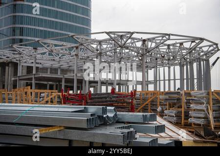 Viel befahrene Baustelle und jede Menge Baumaterial, Ausrüstung, Werkzeuge, schwere Maschinen und Kräne. Stockfoto