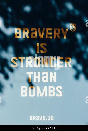 Ukraine, Kiew. 24. August 2024 Gelber Text "Tapferkeit ist stärker als Bomben" auf blauem Hintergrund. Krieg in der Ukraine. russland ist ein Terrorstaat. Mutig ua. Stockfoto