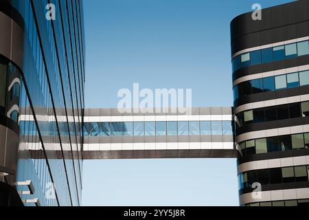 Verbindungsbrücke zwischen zwei Gebäuden mit hellblauem Himmel. Stockfoto