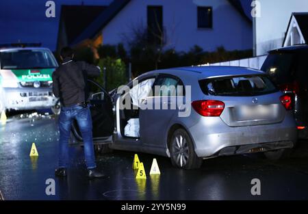 19. Dezember 2024, Bayern, Mühlhausen: Ein Polizeiermittler steht neben dem Unfallfahrzeug. Polizeibeamte haben eine mutmaßliche Fahrerin in Mittelfranken gestoppt, indem sie auf die Reifen ihres Autos geschossen haben. Die Frau habe offenbar mehrere Unfälle in der Region zwischen Geiselwind (Kreis Kitzingen) und Mühlhausen (Kreis Erlangen-Höchstadt) verursacht, so ein Polizeisprecher. Foto: Daniel Löb/dpa Stockfoto